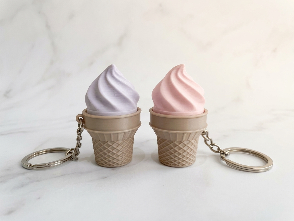 Soft-serve ice cream cone keychains in pastel lavender and pink